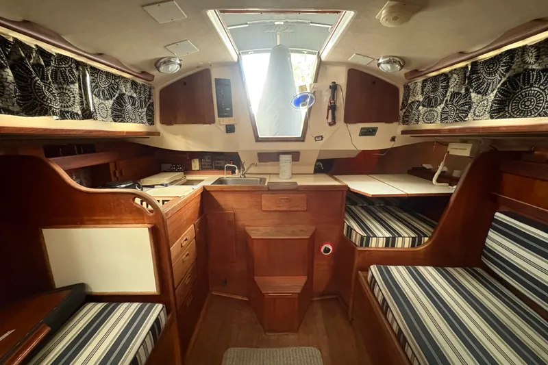 Slide: The Image of Interior of 1981 Sabre 31 sailboat with striped seating and compact kitchen area. - 24