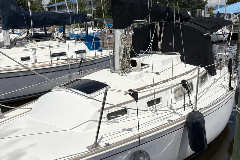 Slide: The Image of 1981 Sabre 31 sailboat docked, for sale sign displayed, marina background. - 5