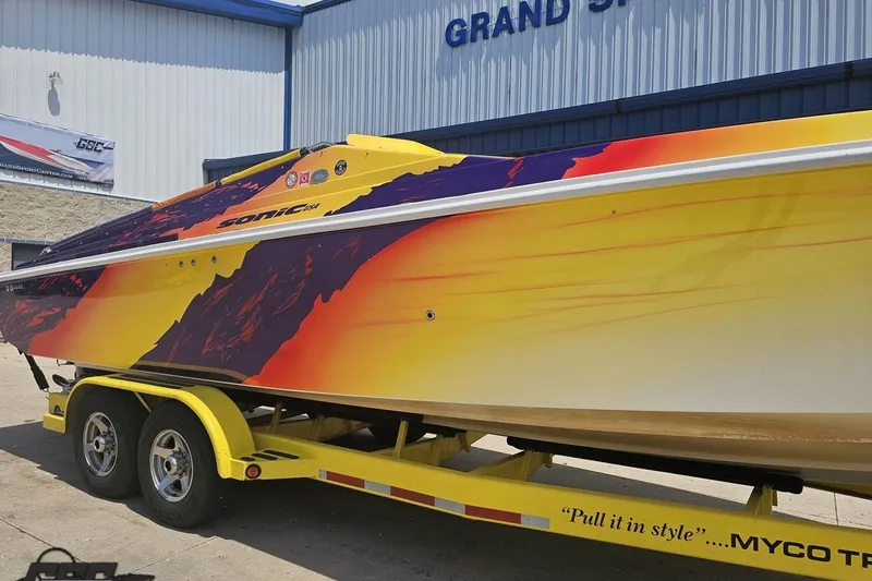 Slide: The Image of 2003 Sonic USA 31SS speedboat with vibrant sunset-themed design on a yellow trailer. - 10