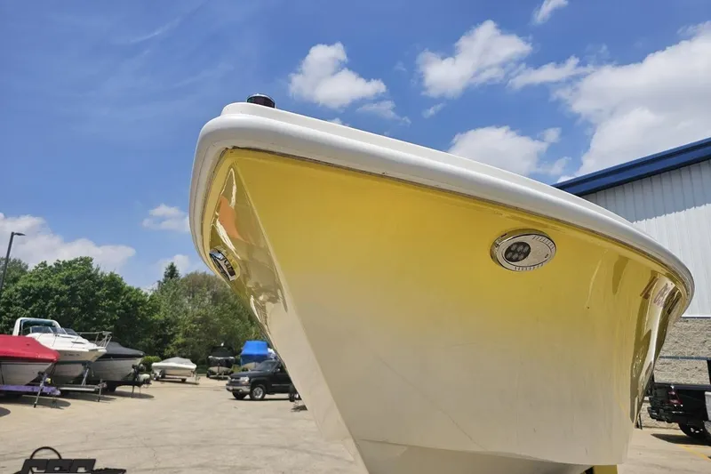 Slide: The Image of 2003 Sonic USA 31SS boat with yellow hull, parked outdoors under a blue sky. - 13