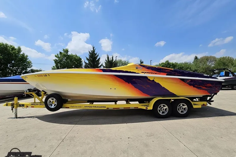 Slide: The Image of 2003 Sonic USA 31SS speedboat with vibrant graphics on a trailer, under a clear blue sky. - 17