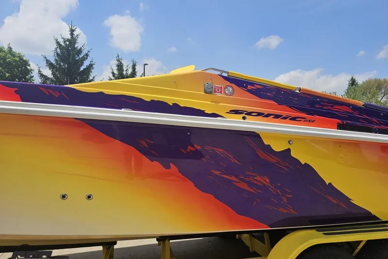 Slide: The Image of Colorful 2003 Sonic USA 31SS boat with vibrant yellow, orange, and purple design. - 18