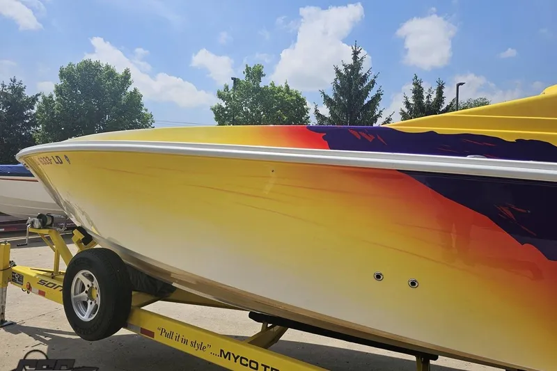 Slide: The Image of 2003 Sonic USA 31SS speedboat with vibrant yellow and red design on a trailer. - 19