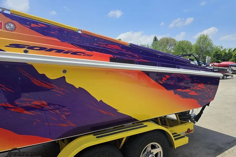 Slide: The Image of Colorful 2003 Sonic USA 31SS speedboat with vibrant graphics on a trailer. - 20