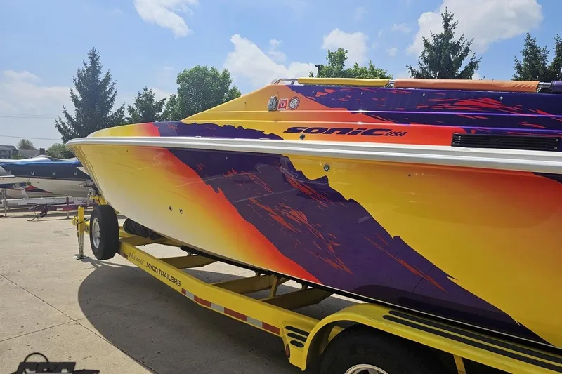 Slide: The Image of Colorful 2003 Sonic USA 31SS speedboat on trailer, vibrant design, sunny day. - 22