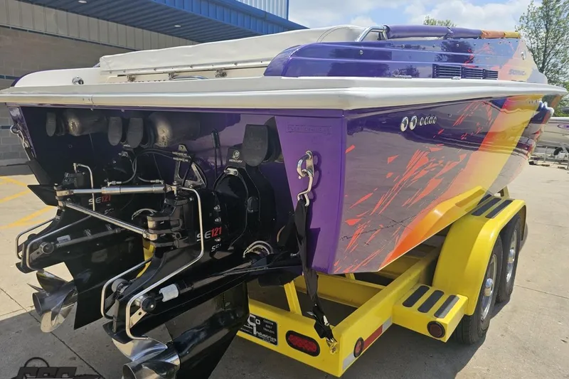 Slide: The Image of 2003 Sonic USA 31SS speedboat with vibrant purple and orange design on a yellow trailer. - 28