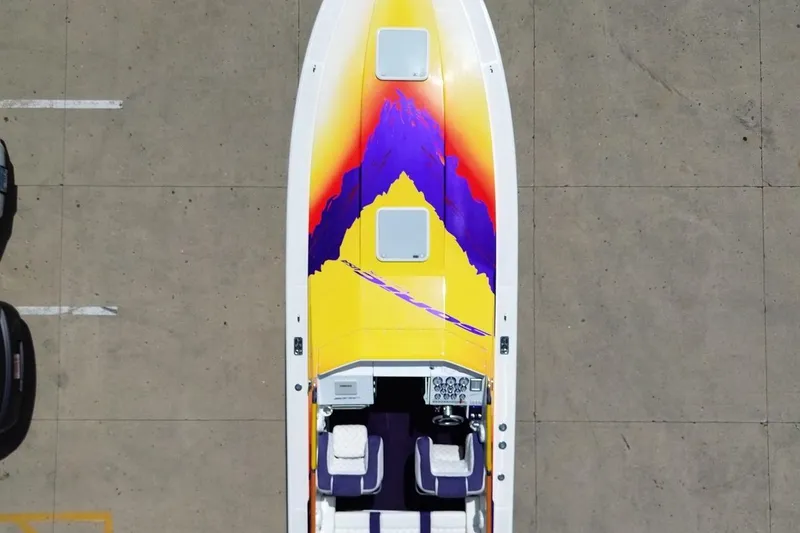 Slide: The Image of Aerial view of 2003 Sonic USA 31SS boat with vibrant yellow and purple design. - 33