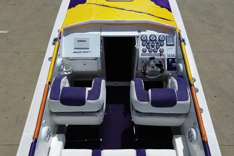Slide: The Image of 2003 Sonic USA 31SS boat interior with vibrant yellow and purple accents, dual seating, and control panel. - 35