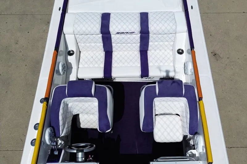 Slide: The Image of 2003 Sonic USA 31SS boat interior with white and purple seating, steering wheel visible. - 37