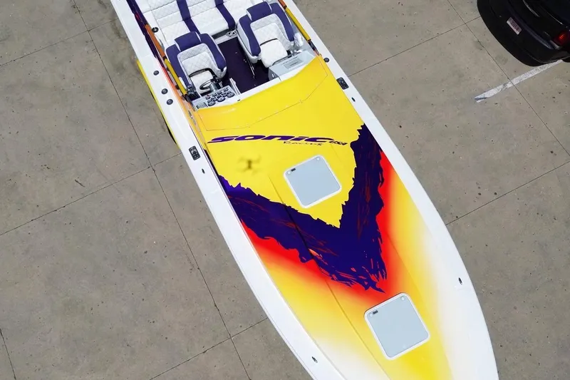 Slide: The Image of 2003 Sonic USA 31SS speedboat with vibrant yellow and purple design, aerial view. - 38