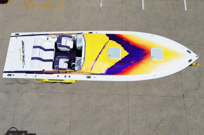 Slide: The Image of Aerial view of 2003 Sonic USA 31SS speedboat with vibrant yellow and purple design. - 40