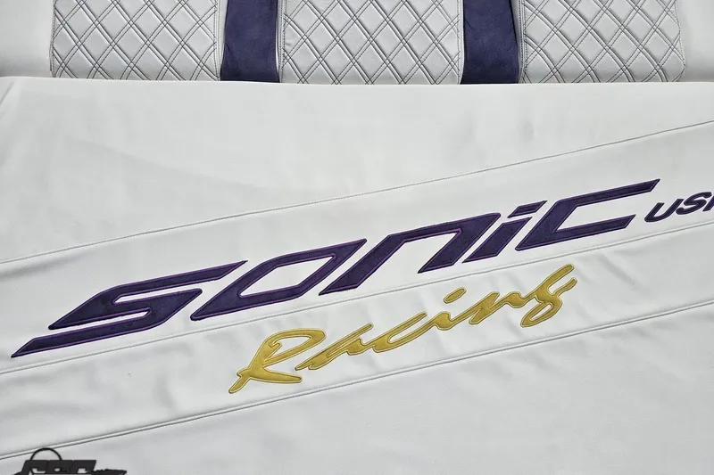 Slide: The Image of 2003 Sonic USA 31SS logo on white leather with quilted pattern background. - 47