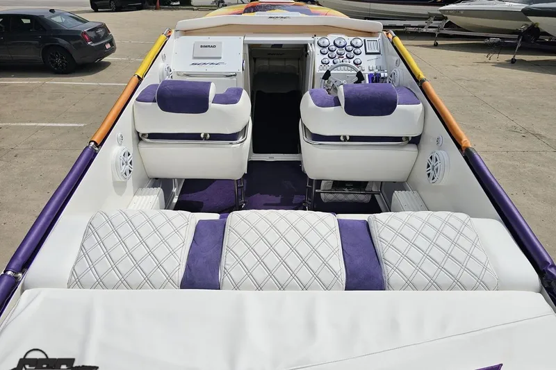 Slide: The Image of 2003 Sonic USA 31SS boat interior with purple and white seating, dashboard, and controls. - 49