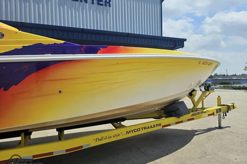 Slide: The Image of 2003 Sonic USA 31SS speedboat with vibrant yellow and orange design on a trailer. - 5