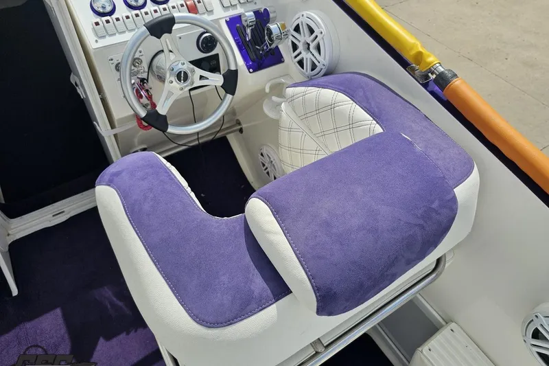Slide: The Image of Cockpit of 2003 Sonic USA 31SS boat with purple and white seating, steering wheel, and controls. - 55