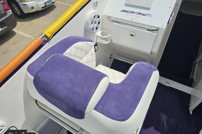 Slide: The Image of 2003 Sonic USA 31SS boat interior with purple and white seating, speaker, and storage compartment. - 56