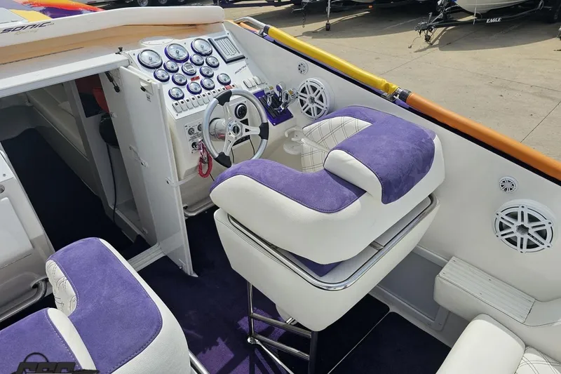 Slide: The Image of Interior of a 2003 Sonic USA 31SS boat with purple and white seating. - 58
