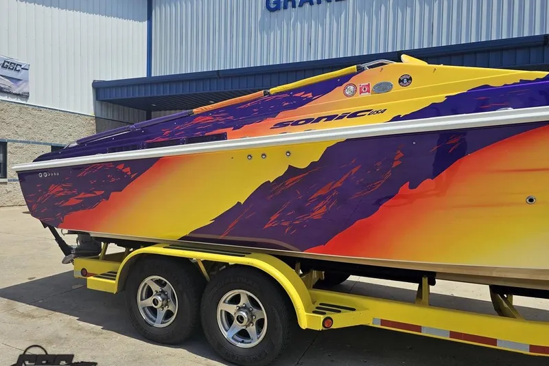 Slide: The Image of Colorful 2003 Sonic USA 31SS speedboat on trailer, vibrant purple and yellow design. - 6
