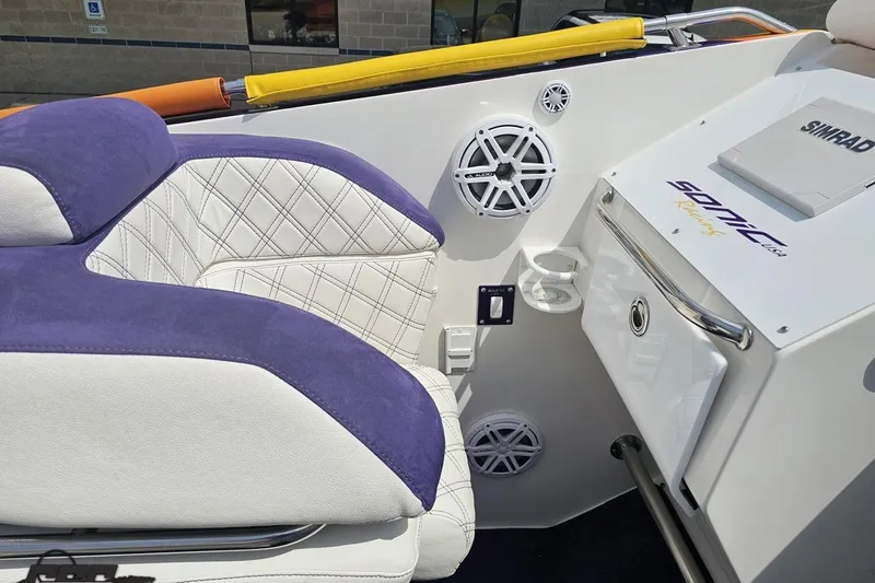 Slide: The Image of Interior of 2003 Sonic USA 31SS boat with purple and white seating, speakers, and control panel. - 61