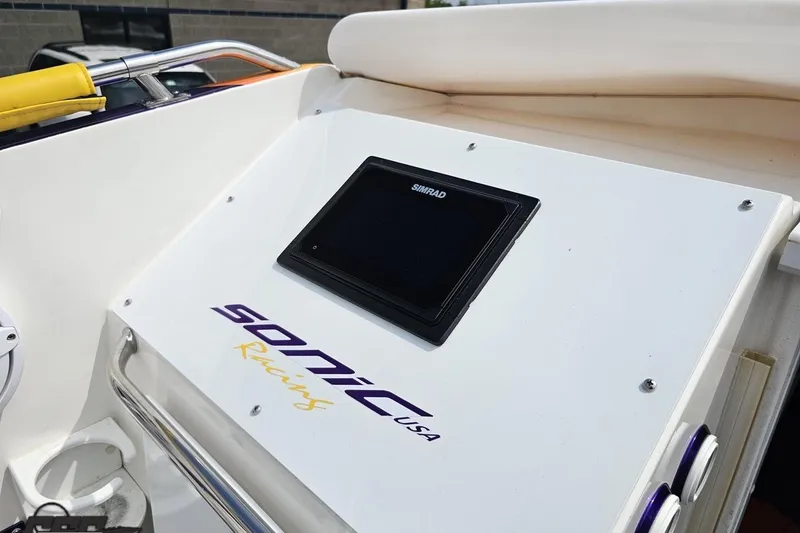 Slide: The Image of 2003 Sonic USA 31SS boat dashboard with Simrad display and racing logo. - 62