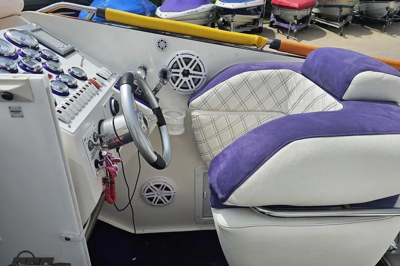 Slide: The Image of Cockpit of 2003 Sonic USA 31SS boat with purple and white seating, steering wheel, and gauges. - 64