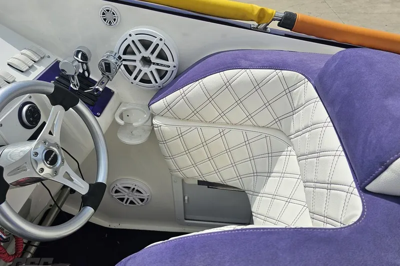 Slide: The Image of Interior of a 2003 Sonic USA 31SS boat with steering wheel and plush seating. - 65