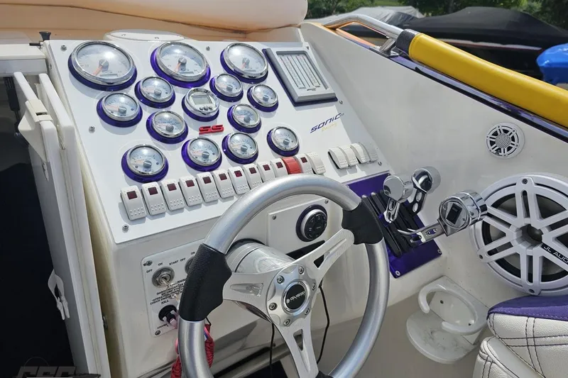 Slide: The Image of Control panel of a 2003 Sonic USA 31SS boat with gauges and steering wheel. - 66