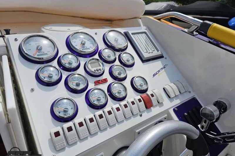 Slide: The Image of Control panel of a 2003 Sonic USA 31SS boat with gauges and switches. - 67