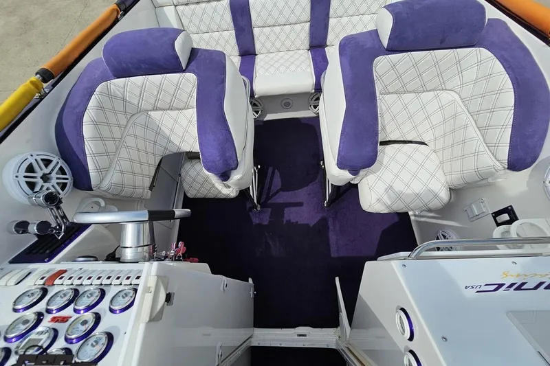 Slide: The Image of Interior of a 2003 Sonic USA 31SS boat with purple and white seating. - 73