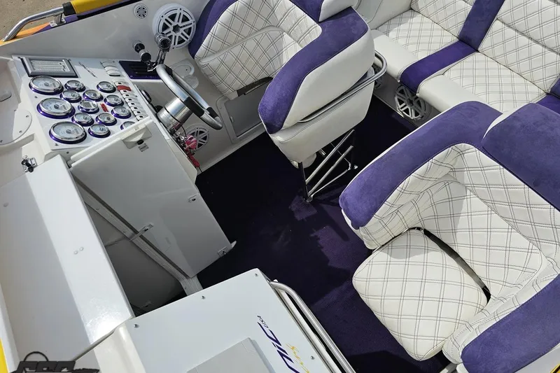 Slide: The Image of Interior of 2003 Sonic USA 31SS boat with purple and white seating and control panel. - 74