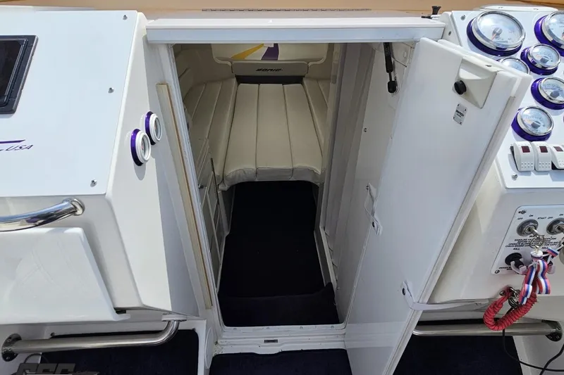 Slide: The Image of Interior cabin view of a 2003 Sonic USA 31SS boat, featuring white seating and control panel. - 75