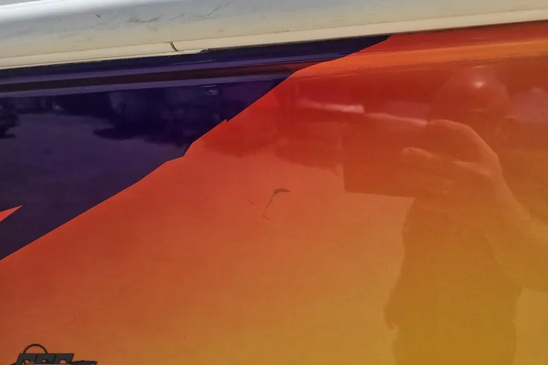 Slide: The Image of Close-up of a 2003 Sonic USA 31SS boat with orange and purple paint. - 8