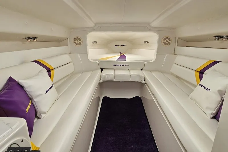 Slide: The Image of Interior of 2003 Sonic USA 31SS boat with white seating and purple accents. - 82