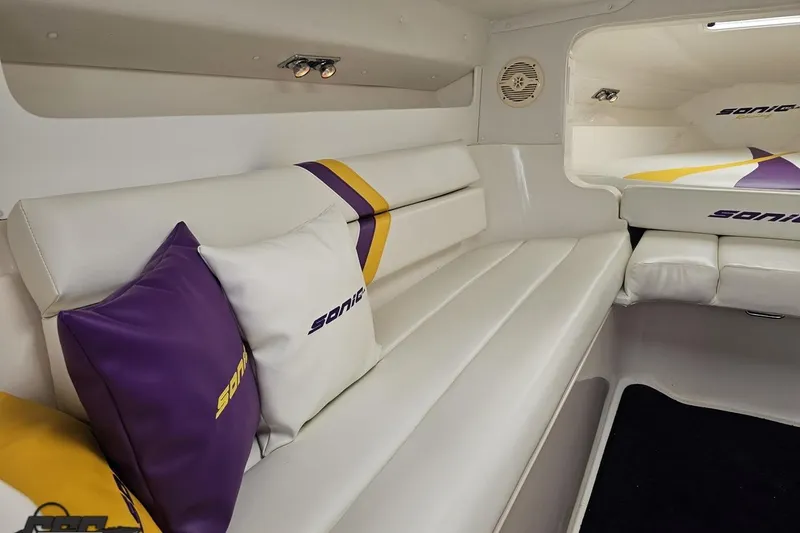 Slide: The Image of Interior of 2003 Sonic USA 31SS boat with white and purple seating. - 85