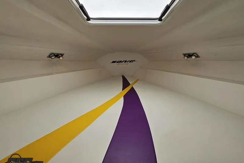 Slide: The Image of Interior view of 2003 Sonic USA 31SS boat with vibrant yellow and purple design. - 88