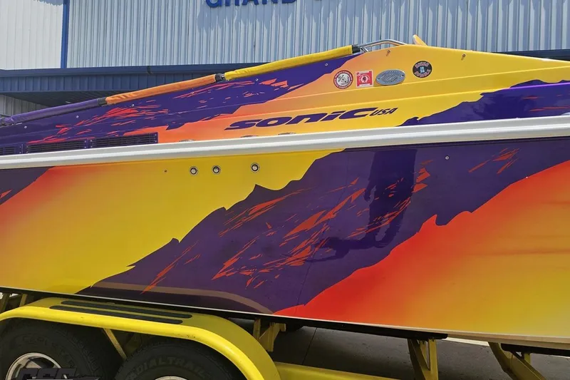 Slide: The Image of 2003 Sonic USA 31SS boat with vibrant yellow and purple design. - 9