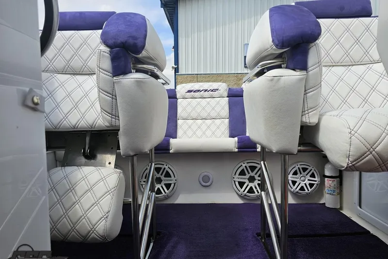Slide: The Image of Interior of a 2003 Sonic USA 31SS boat with white and purple seating. - 91