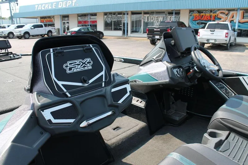 Slide: The Image of 2019 Skeeter FX21 LE boat interior with steering wheel and control panel, parked outside tackle shop. - 10