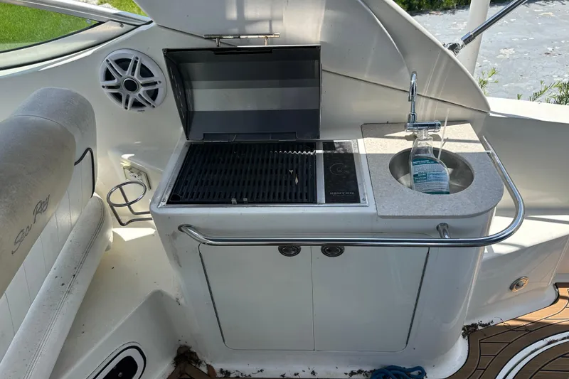 Slide: The Image of 2009 Sea Ray 270 Sundancer boat interior with grill and sink setup. - 10