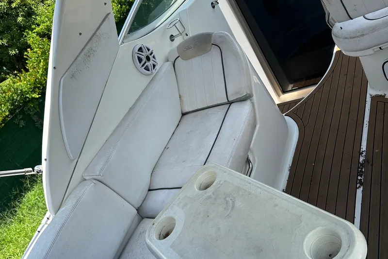 Slide: The Image of Interior of 2009 Sea Ray 270 Sundancer boat with white seating and wooden flooring. - 11
