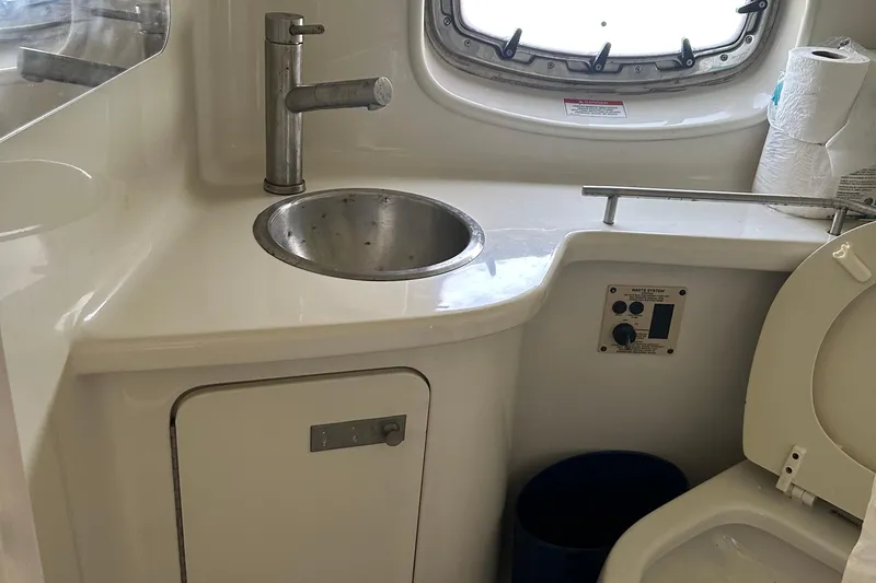 Slide: The Image of 2009 Sea Ray 270 Sundancer bathroom with sink, toilet, and window view. - 7