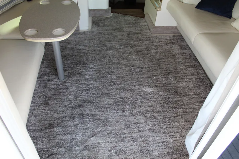 Slide: The Image of Interior of 1997 Sea Ray 400 Sedan Bridge with gray carpet and seating area. - 11