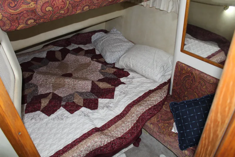 Slide: The Image of Cozy bedroom in 1997 Sea Ray 400 Sedan Bridge with patterned quilt and pillows. - 18