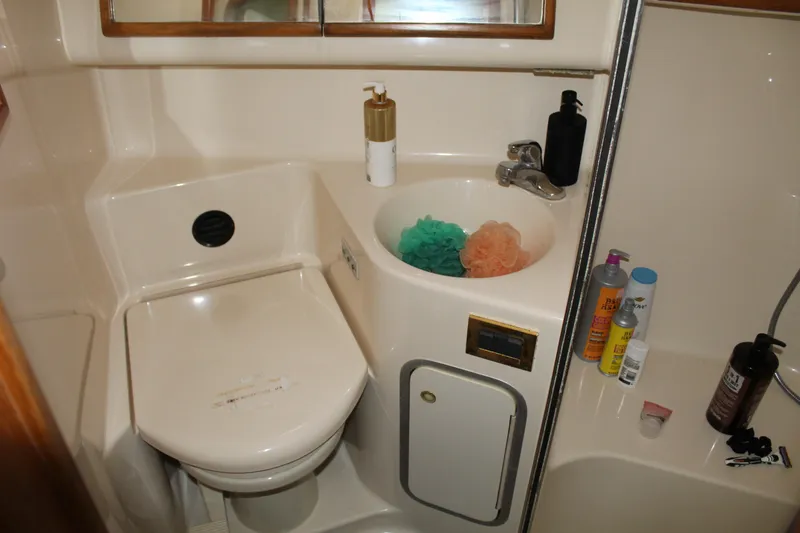 Slide: The Image of Bathroom of 1997 Sea Ray 400 Sedan Bridge with sink, toilet, and toiletries. - 19