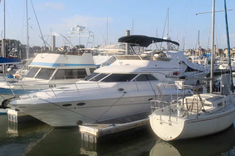Slide: The Image of 1997 Sea Ray 400 Sedan Bridge yacht docked in a marina, surrounded by other boats. - 2
