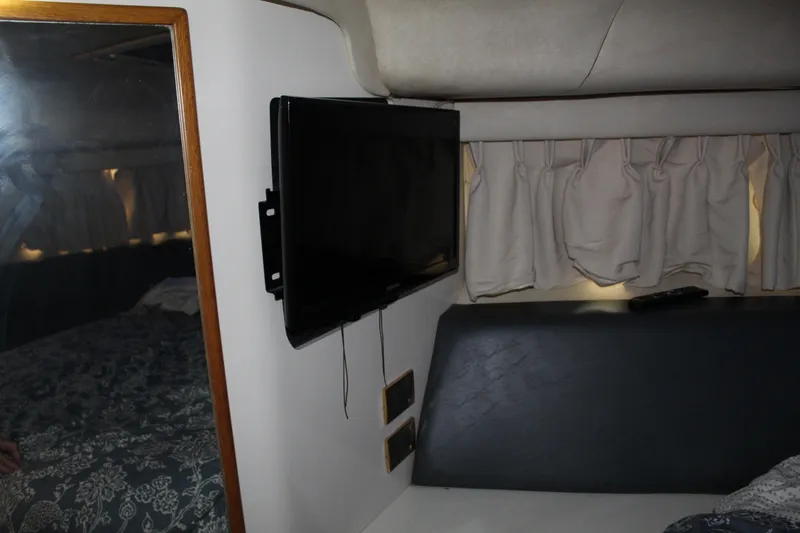 Slide: The Image of Interior of 1997 Sea Ray 400 Sedan Bridge with TV and curtains. - 24