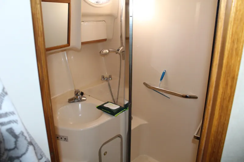 Slide: The Image of Bathroom interior of 1997 Sea Ray 400 Sedan Bridge yacht, featuring sink and shower. - 25