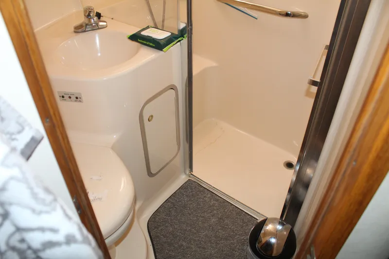 Slide: The Image of Bathroom interior of 1997 Sea Ray 400 Sedan Bridge yacht, featuring sink and shower. - 26