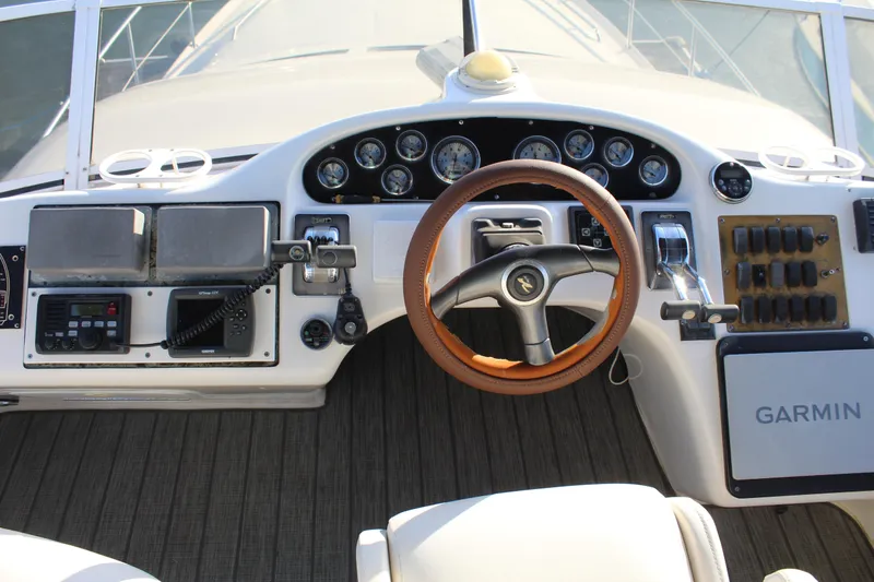 Slide: The Image of 1997 Sea Ray 400 Sedan Bridge helm with gauges, Garmin navigation, and wood-accented steering wheel. - 30