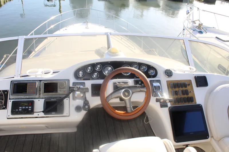 Slide: The Image of 1997 Sea Ray 400 Sedan Bridge helm with gauges, controls, and wooden steering wheel. - 31